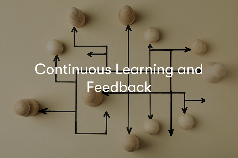 Wooden people with black arrows pointing to each other with the wording Continuous Learning and Feedback in front