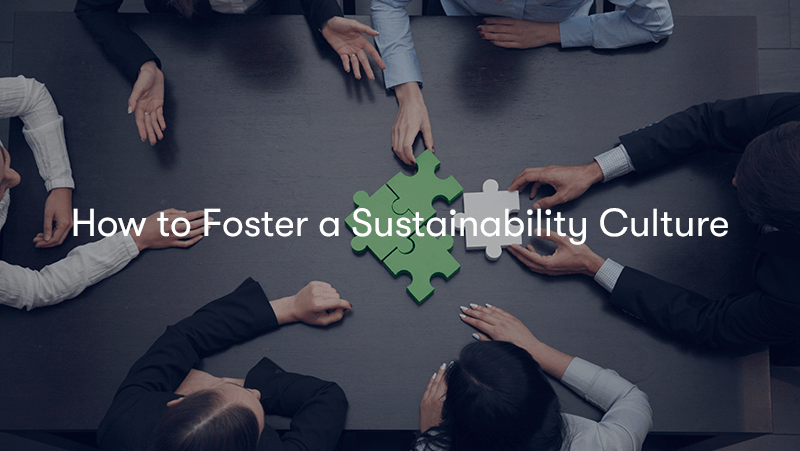 Business people sat around a desk making a green jigsaw together, with the words 'How to Foster a Sustainability Culture' on top.