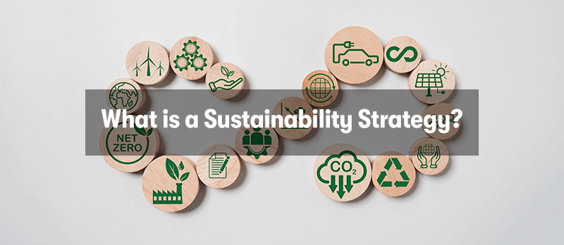 A picture of a sustainability workflow made up of wooden disks with symbols on them for recycling, CO2, power plants, green energy, and paper work. With the heading 'What is a Sustainability Strategy?' in front.