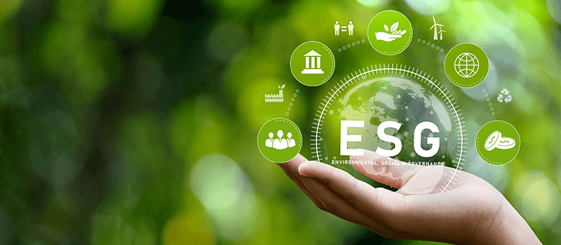 A picture of a hand holding a globe, with the words ESG on it. Surrounding that is icons symbolising money, connection, sustainability, people, and production.