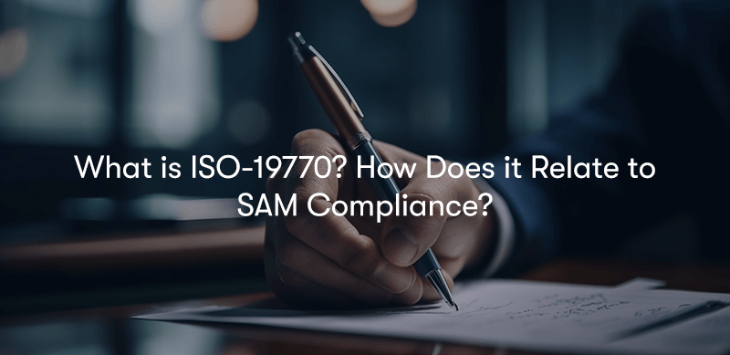 A picture of someone signing a document with a pen, with the text 'What is ISO-19770? How Does it Relate to SAM Compliance?' in front.
