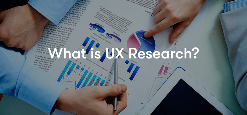 What is UX research text and behind two people analysing a piece of paper with graphs and charts on it