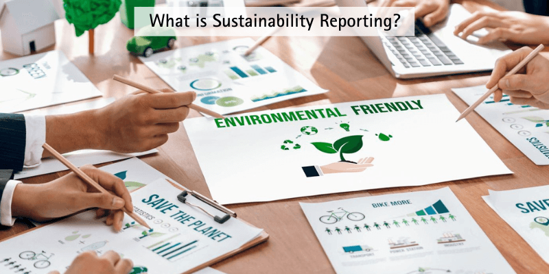 A picture of many pieces of paper with graphs and stats on them, with people working around a desk on them. With one piece of paper in the middle saying environmentally friendly. With the heading 